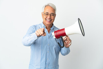 Middle age Brazilian man isolated on white background holding a megaphone and smiling while pointing to the front