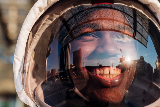 Smiling man wearing space helmet looking away during sunny day