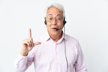 Telemarketer Middle age man working with a headset isolated on white background intending to realizes the solution while lifting a finger up
