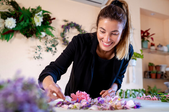 Happy female florist making flower decoration at workshop