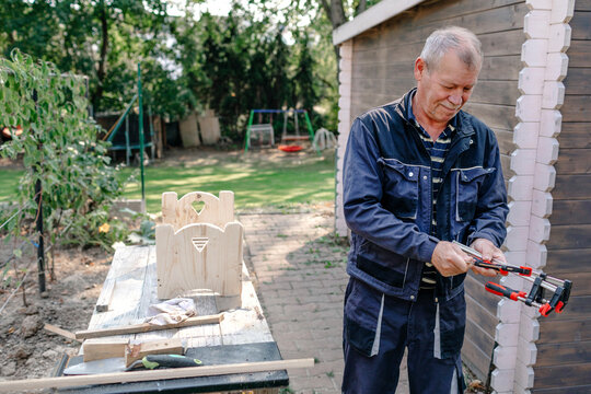 Senior man doing carpentry work in backyard