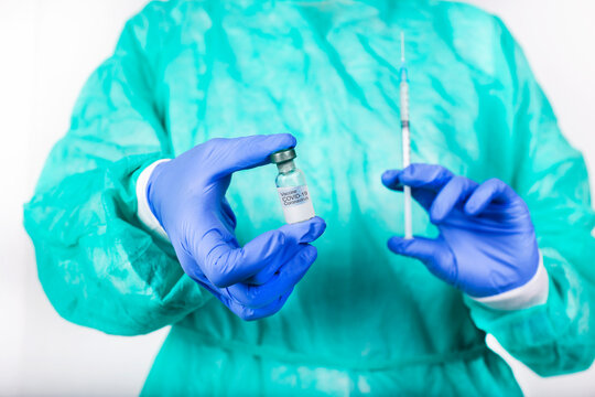 Hands of doctor holding Covid-19 vaccine and syringe