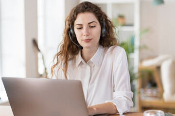 Beautiful female customer service representative using laptop at home office