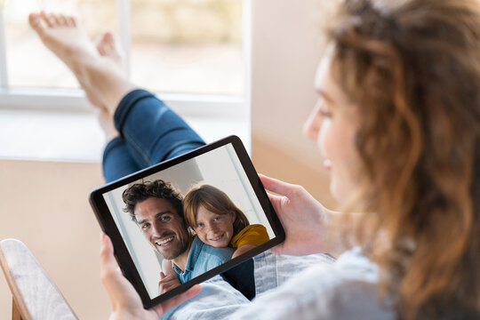 Woman talking on video call through digital tablet while sitting at home