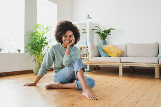 Smiling woman sitting on floor at home
