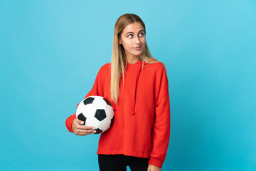 Young football player woman isolated on blue background thinking an idea while looking up