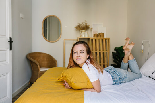 Smiling woman lying on bed at home