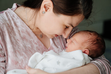 mother with newborn baby in her arms. close-up. happiness of motherhood and love