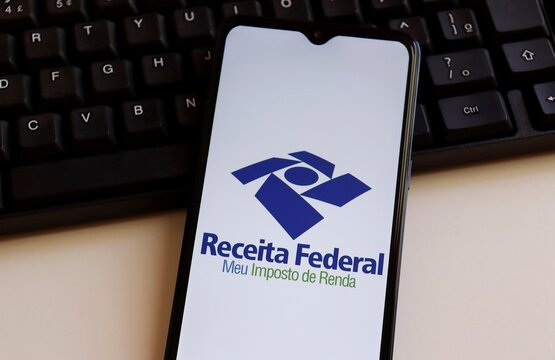 Brazil: Receita Federal - Meu imposto de Renda (Brazilian Federal Revenue Department) logo on smartphone screen on computer keyboard. Income tax declaration in Brazil.
