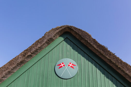 Denmark, Romo, Danish flags painted under thatched roof of fire station