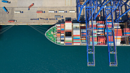 Aerial drone top down photo of industrial cargo container ship loading or unloading with help of cranes in Mediterranean logistics terminal port