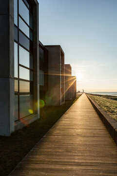 Denmark, Romo, Boardwalk along row of modern summer houses at sunset