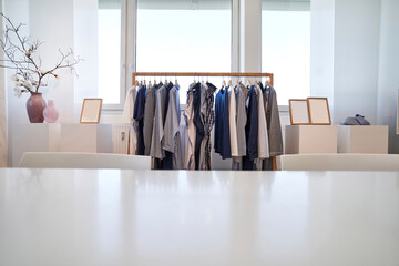 Garments hanging on rack in clothes design studio