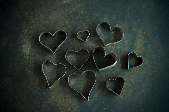 Heart shape cookie cutters on rustic baking sheet