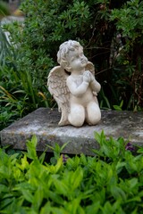 Fototapeta na wymiar small kneeling white angel statue praying on a grave in an Austrian village
