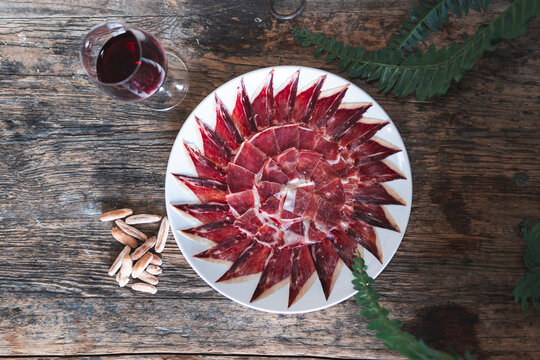 Red meat slice arranged in pattern on table by drink