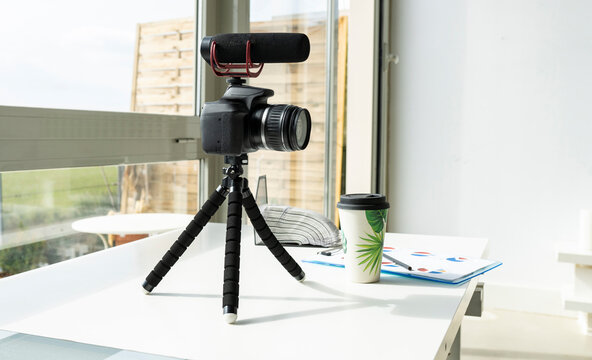 Video camera with reusable cup on table at home
