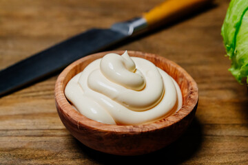 white sauce. small wooden bowl with mayonnaise on the kitchen table. 