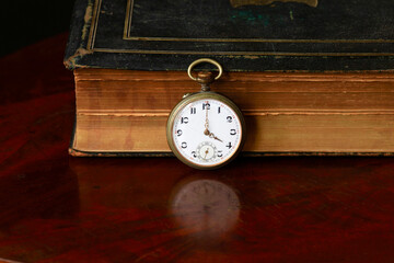 Studio shot of old book and antique pocket watch