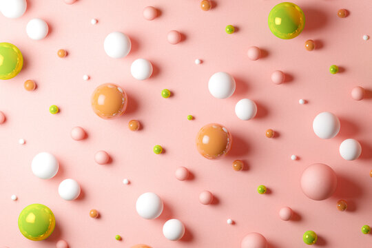Three dimensional pattern of various spheres flat laid against pink background