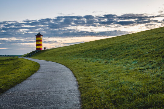 Germany, Lower Saxony, Krummhorn, Footpath leading to Pilsum Lighthouse at dusk