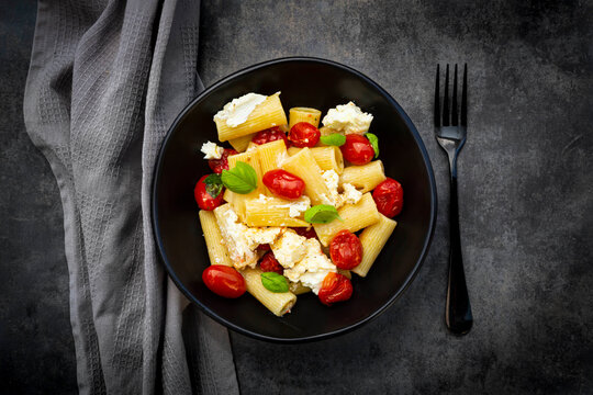 Rigatoni pasta with baked tomatoes, feta and basil