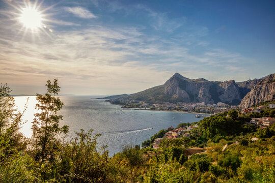 Croatia, Split-Dalmatia County, Omis, Sun setting over coastal town situated at confluence of Adriatic Sea and Cetina river