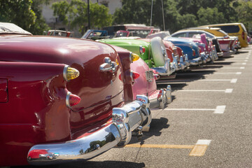 Multi colored cars parked in parking lot on sunny day