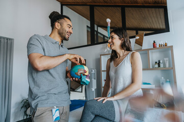 Smiling male physical therapist explaining skull model to female patient in practice