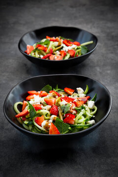 Two bowls of strawberry cucumber salad with feta, mint and balsamico vinegar