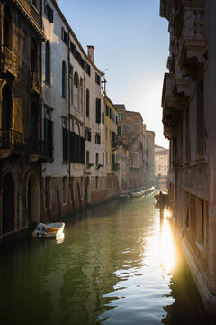Italy, Veneto, Venice, Old houses along narrow city canal at dusk