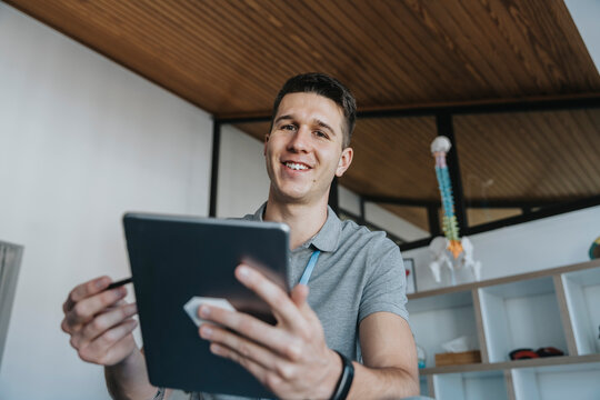 Male physiotherapist holding digital tablet in medical practice