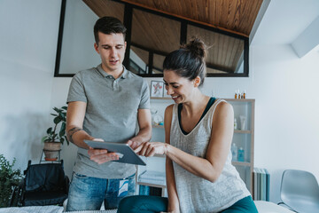 Smiling female patient with physiotherapist looking at digital tablet in medical practice