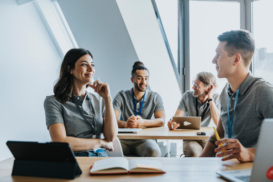 Male and female trainees smiling while discussing in classroom