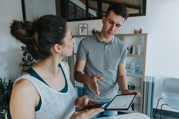 Male physiotherapist with digital tablet discussion with female patient in medical practice