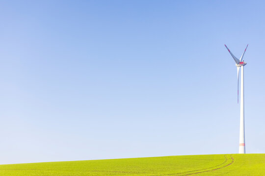 Wind turbine standing against clear blue sky