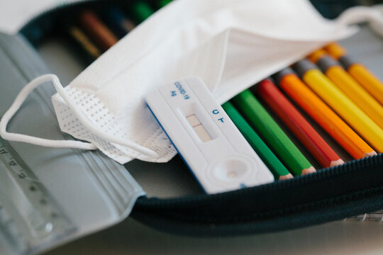 Rapid diagnostic kit with protective face mask in pencil case at school