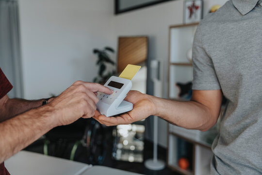 Patient entering pin in card reader in medical practice