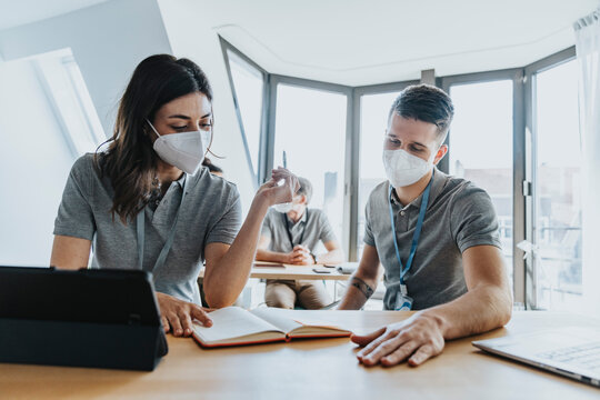 Male and female trainee studying in training class during pandemic