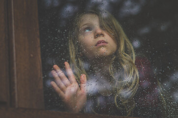 girl behind the window sad and alone