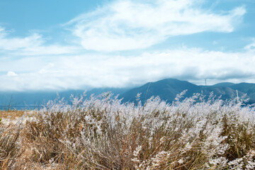 Mountain landscape in Sicily with dry grass, mountains and clouds in the sky. Nature background.