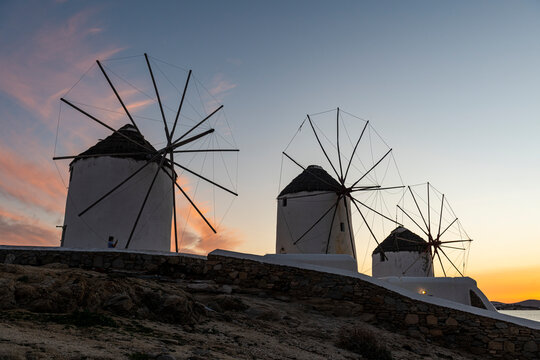 Greece, Mykonos, Horta, Row of windmills at sunset