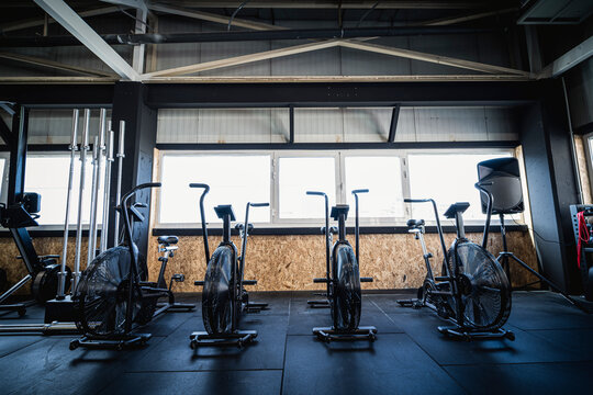Row of exercise bikes standing in empty gym