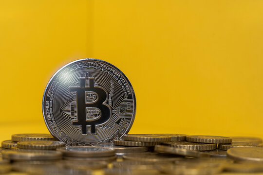Silver colored bitcoin among coins