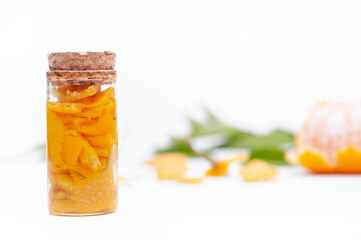 Glass jars of mandarin essences oil, isolated on white background