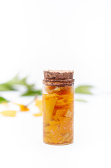 Glass jars of mandarin essences oil, isolated on white background