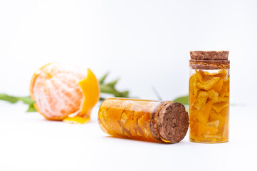 mandarin essences processing, isolated on white background and with mandarins in the background out of focus.