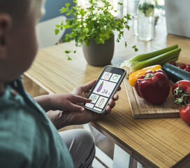 Boy with father pointing at vegetable picture on smart phone