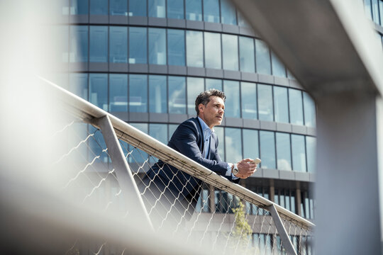 Thoughtful businessman leaning on railing