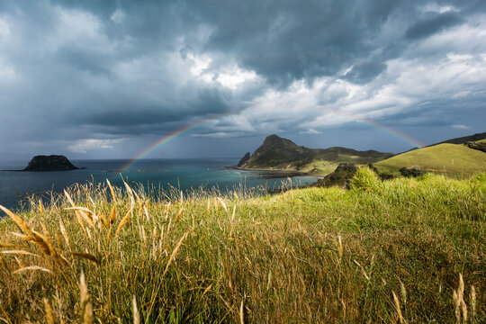 Rainbow arching against storm clouds gathering over coastline of&nbsp;Coromandel&nbsp;Peninsula